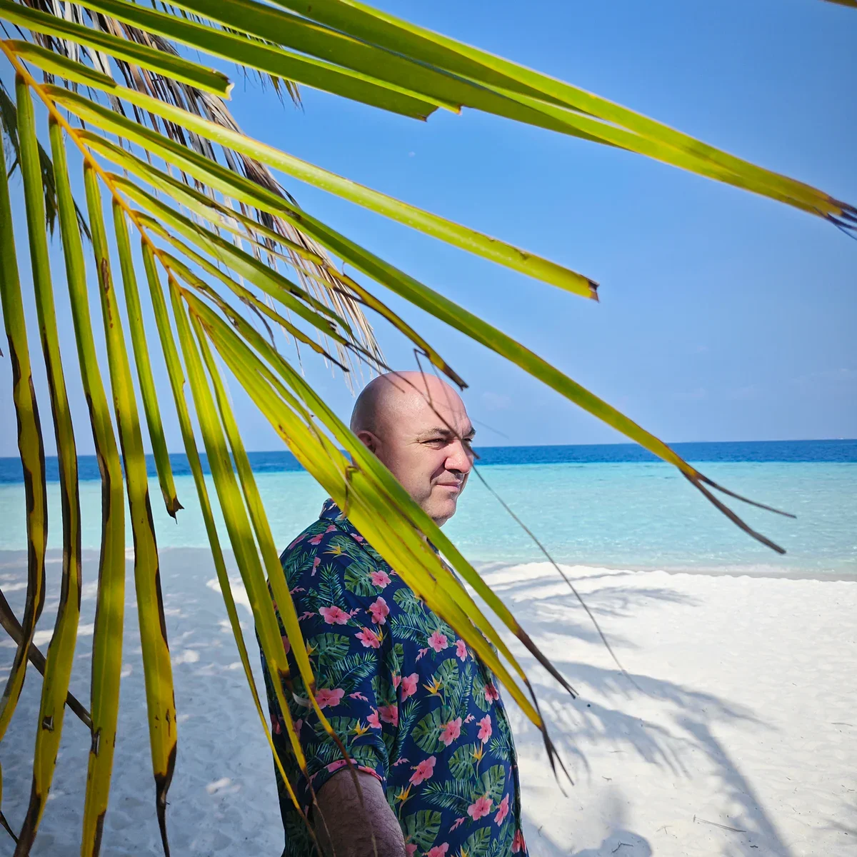 Cristinel Negoita vor Palmen und Strand auf den Malediven